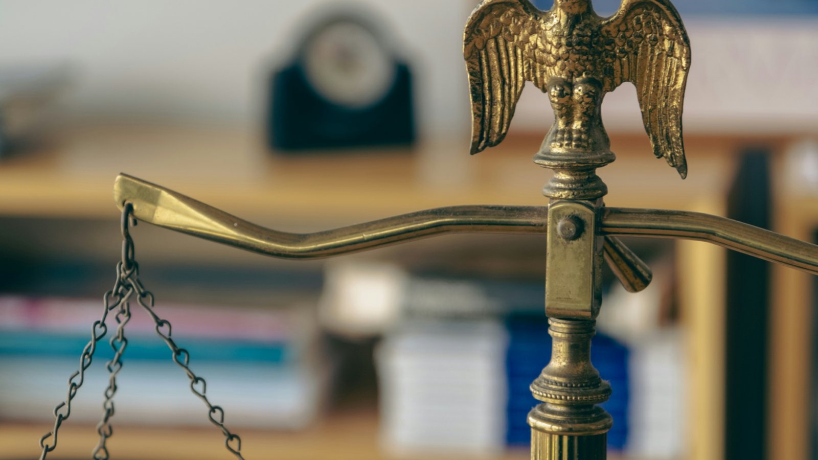 Scales of justice on an office desk with an eagle statue